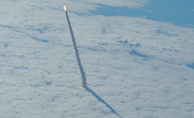 A rocket is seen cutting through clouds.