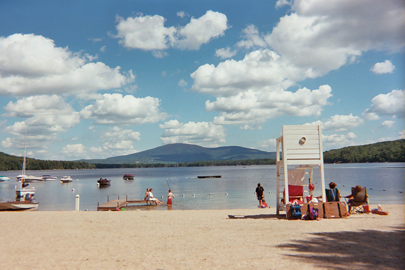 This is a fair weather cumulus cloud scene over a beach or lake  scene.