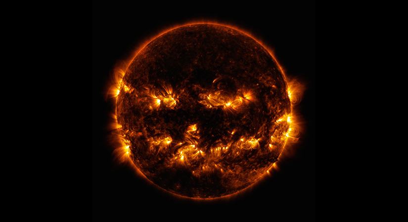 The sun from space with sun flares resembling a jack-o-lantern face.