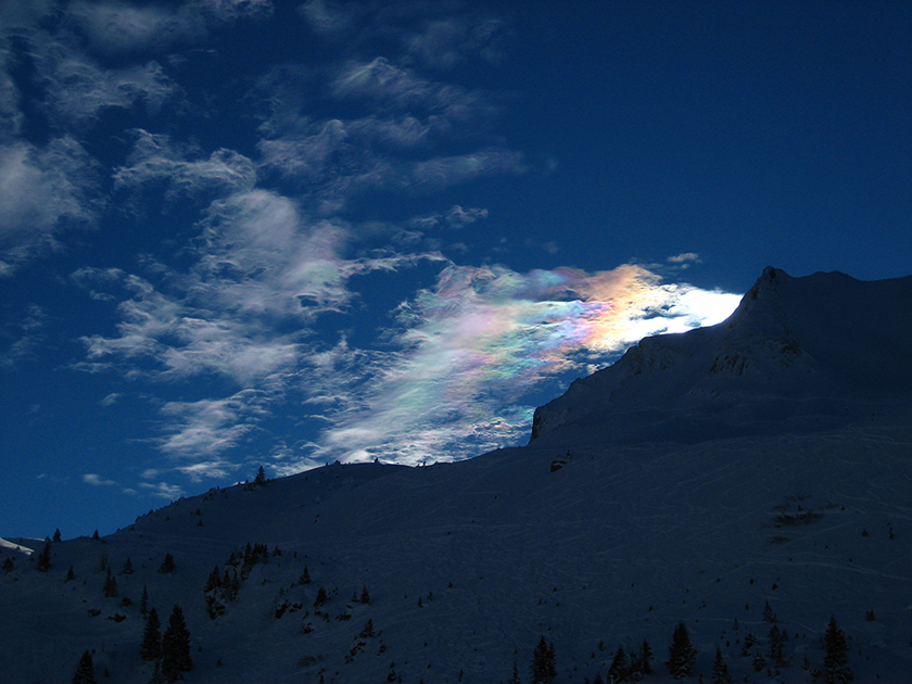 A colorful cloud above a mountain.