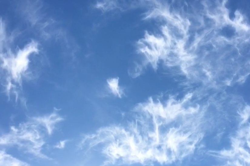 Wispy white clouds in a blue sky.
