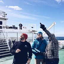 A group of three people look at the clouds.