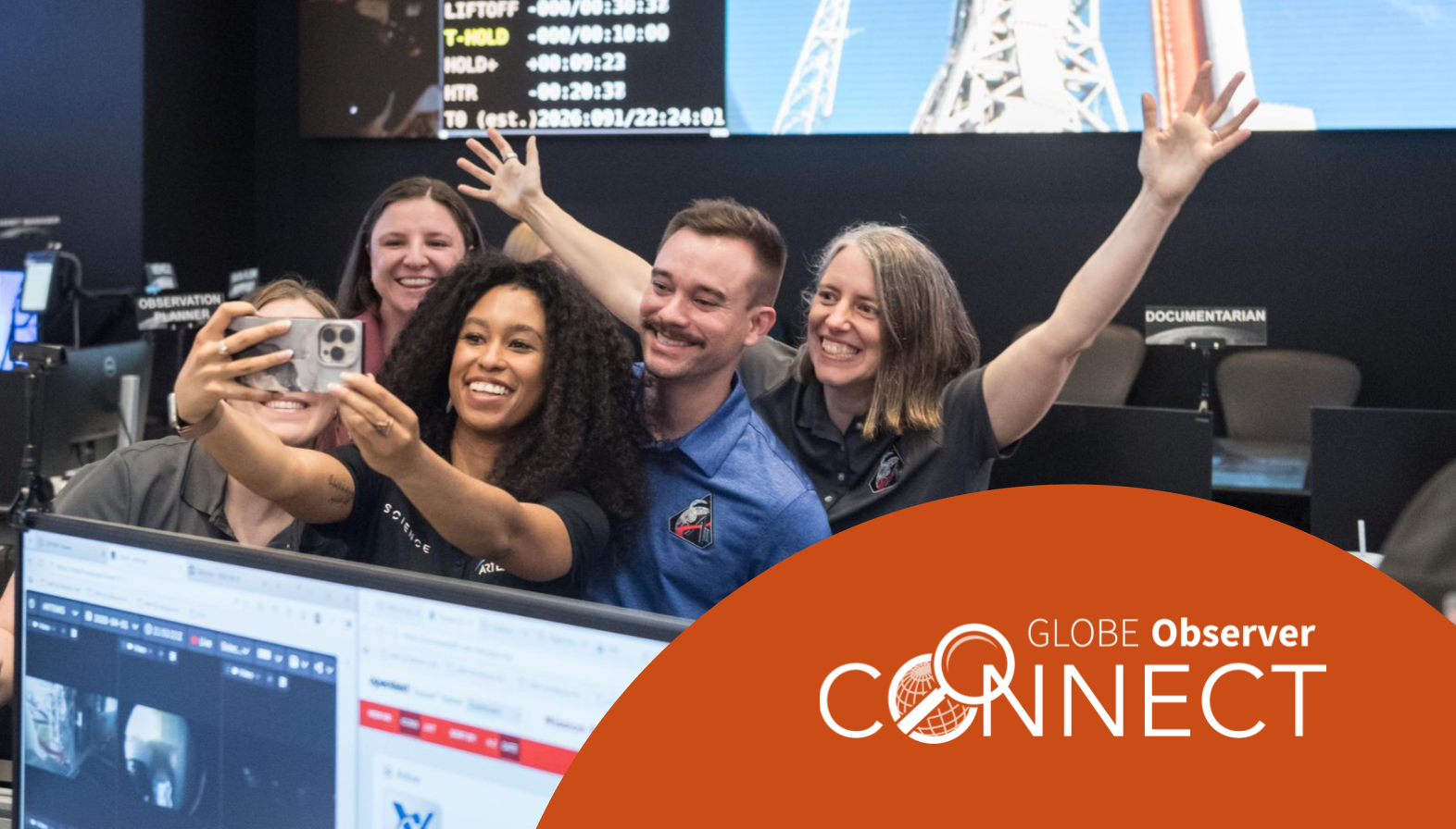 Five smiling people wearing Artemis 2 uniforms taking a selfie in the Science Evaluation Room.