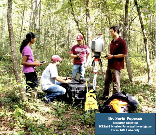 Four researchers in a forest surrounded by a collection of research equipment including a scanner on a tripod and a backpack antenna. One crouches near a rugged storage container and interacts with a laptop.