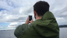 Man observing clouds with phone