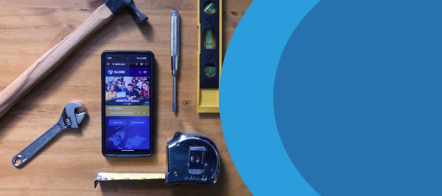 A cell phone showing the GLOBE website, surrounded by tools such as a hammer, wrench, tape measure, etc.