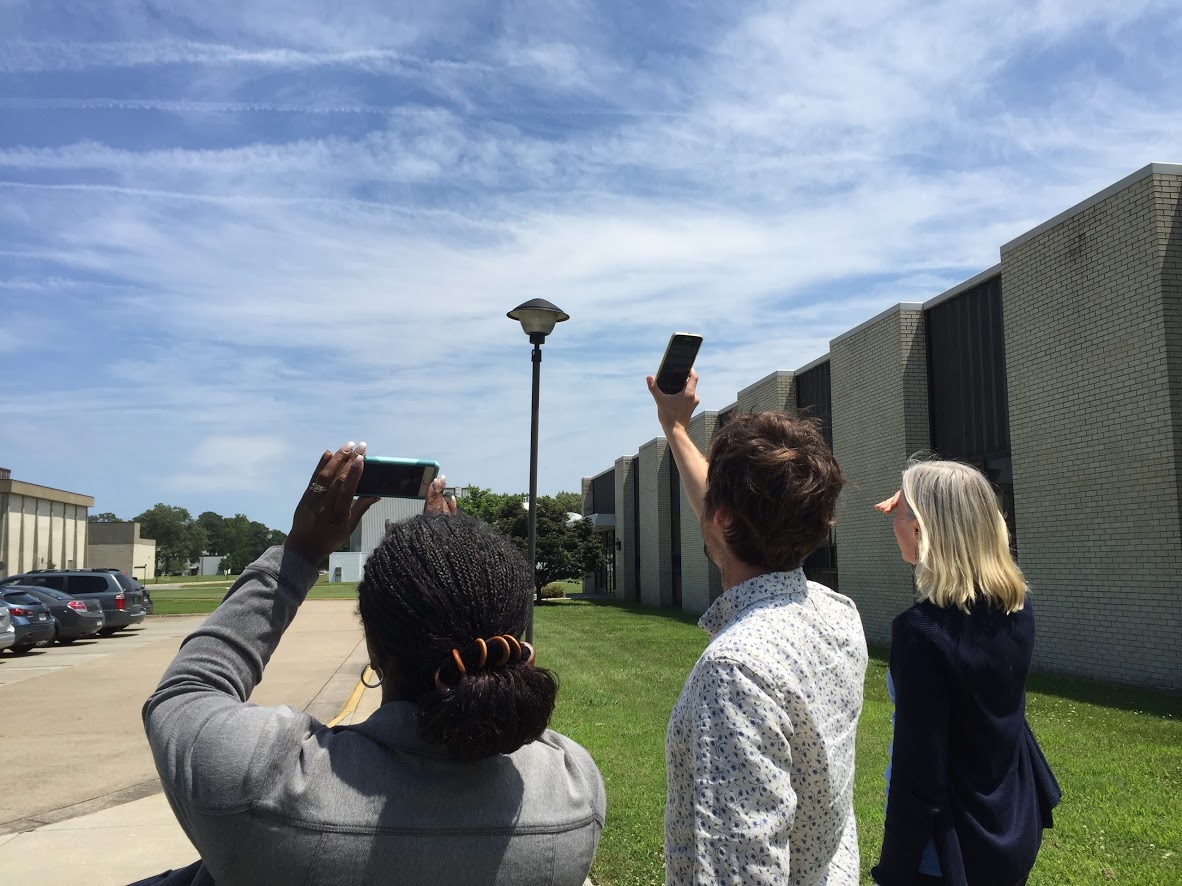 Three people observing the clouds.