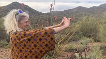 A woman uses a smart device to take a picture of the landscape.