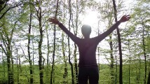 Woman with hands up in the trees