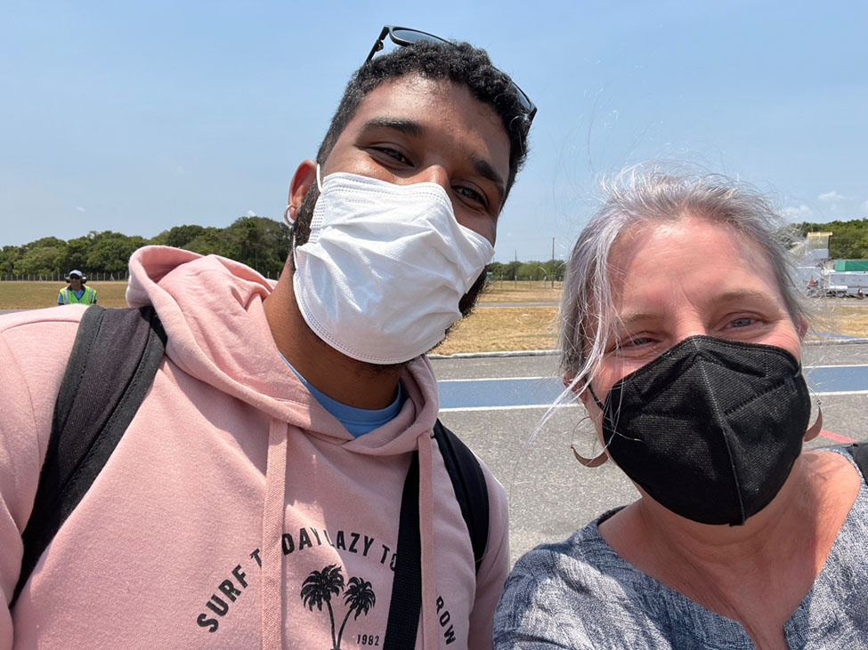 A man and a woman, both wearing masks, look toward the camera in a selfie shot.